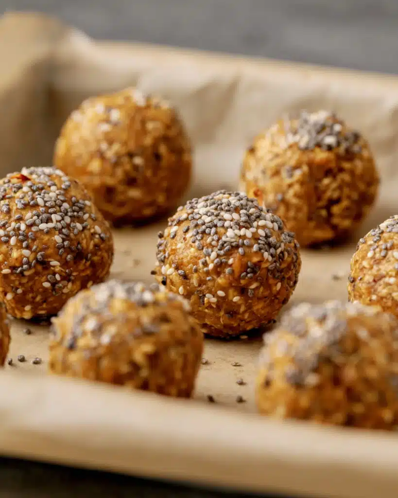 Energy Balls with Dates and Oats and Peanut Butter – Easy Snack 12 Finished energy balls with dates and oats and peanut butter topped with chia seeds on parchment paper