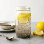 Chia Seeds Water: Easy Daily Drink for Digestion & Energy 7 Mason jar of chia seeds water with lemon slices on marble countertop