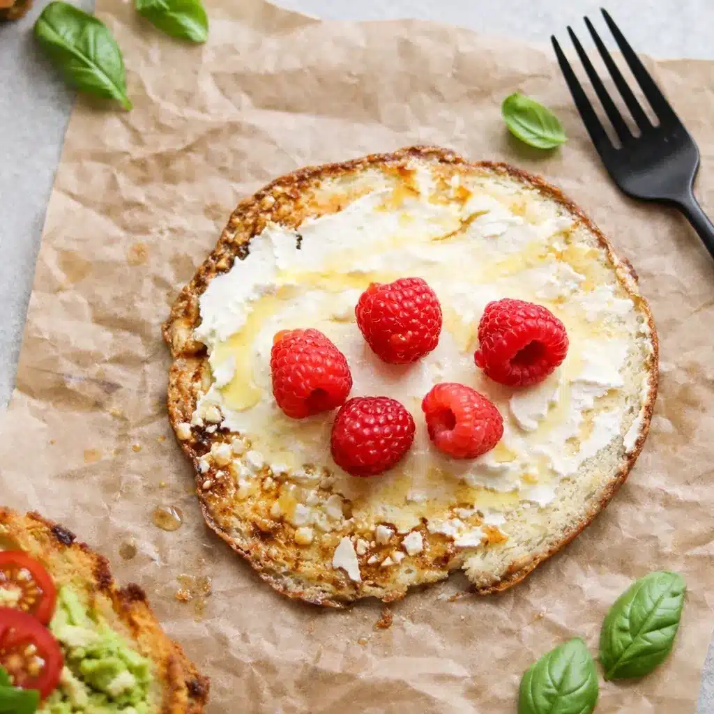 Cottage Cheese Breakfast Rounds topped with cream cheese, raspberries, and honey drizzle on parchment