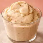 Budwig cream in a glass cup, thick and glossy with ground flaxseed speckles, topped in soft swirls.