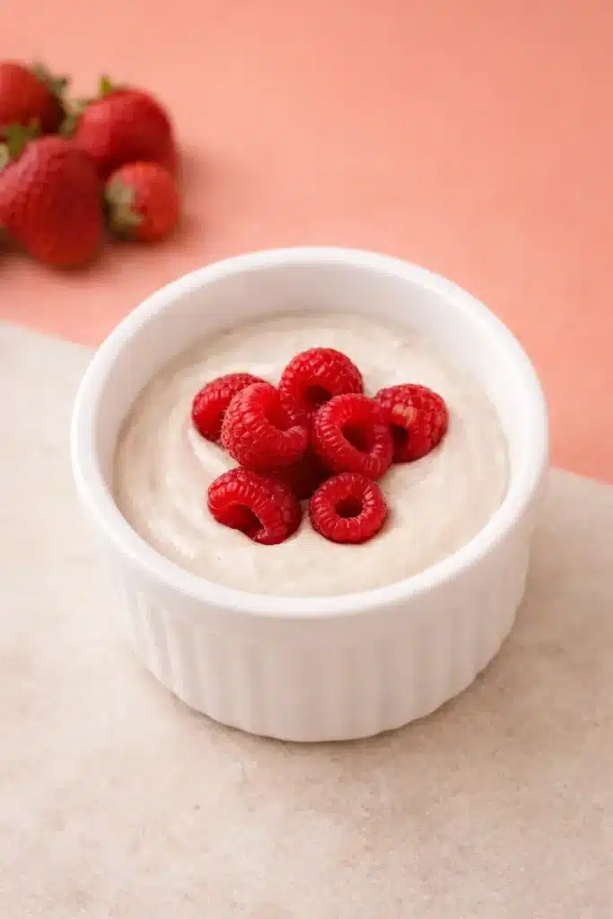Budwig Cream Recipe That Turns Flax and Fruit Into a Creamy Breakfast 9 Budwig cream topped with raspberries in a white ramekin, served as a fresh Budwig cream breakfast bowl.