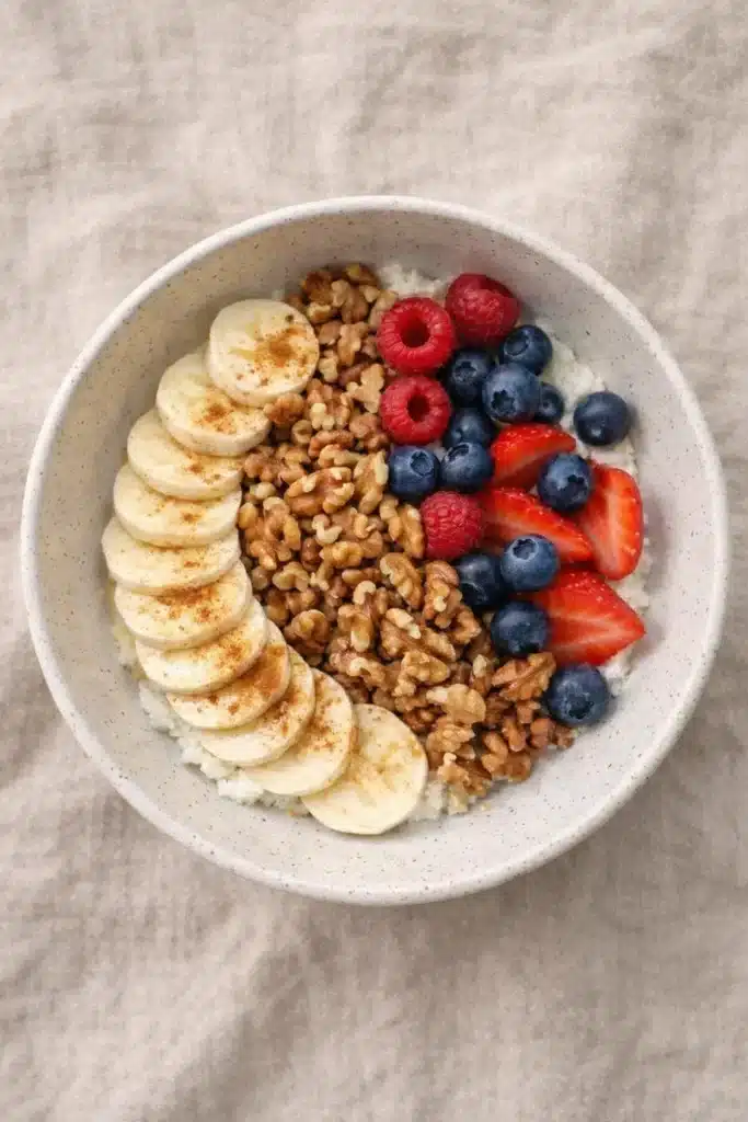Budwig recipe bowl with banana slices, mixed berries, and walnuts on a neutral background