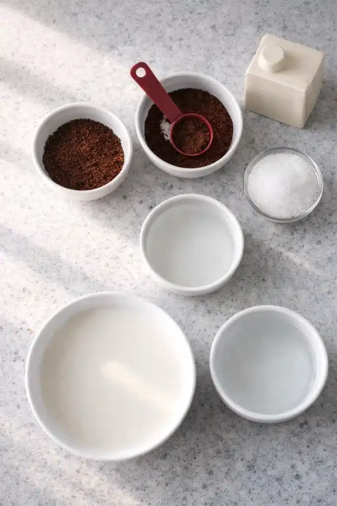 Coffee Jelly Drink Recipe 9 Coffee Jelly Drink recipe ingredients with milk, sugar, coffee granules, and cream on a stone counter