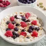 Cottage Cheese Breakfast Bowl with raspberries, blueberries, almonds, and coconut in a white bowl