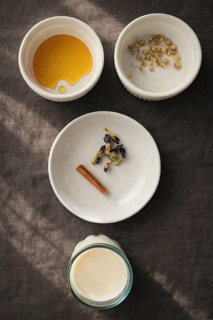 Moon Milk Tea – A Magical Blue Bedtime Drink 9 Moon milk tea ingredients flat lay with honey, chamomile, cinnamon, butterfly pea flowers, and milk