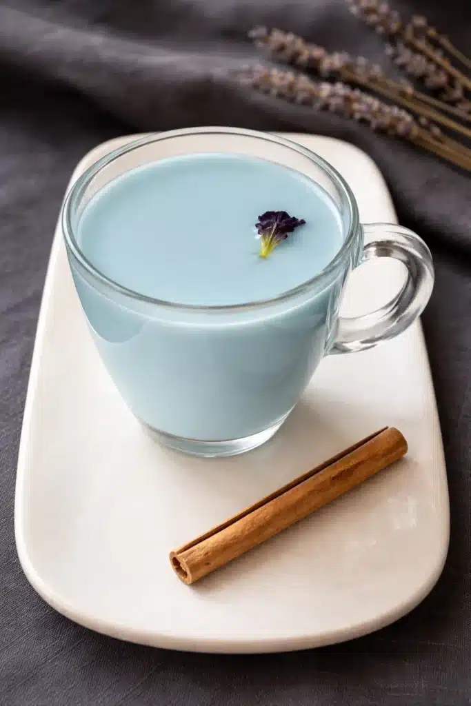 Moon Milk Tea – A Magical Blue Bedtime Drink 14 Moon milk tea in a glass mug with cinnamon and flower garnish, soothing blue bedtime drink